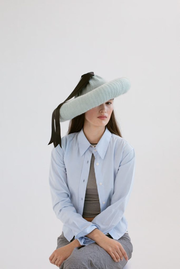 CecilieのハットはNATASCHA DOMINO、シャツはMFPEN、TシャツはLEVIʼS、ネックレスはSOPHIE BILLE BRAHE、スカートはRAVE REVIEW